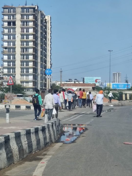 A group of laborers walking back to their homes via NH-24